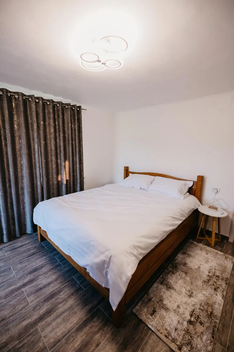 Cameră dublă albă, cu pat matrimonial și draperii groase